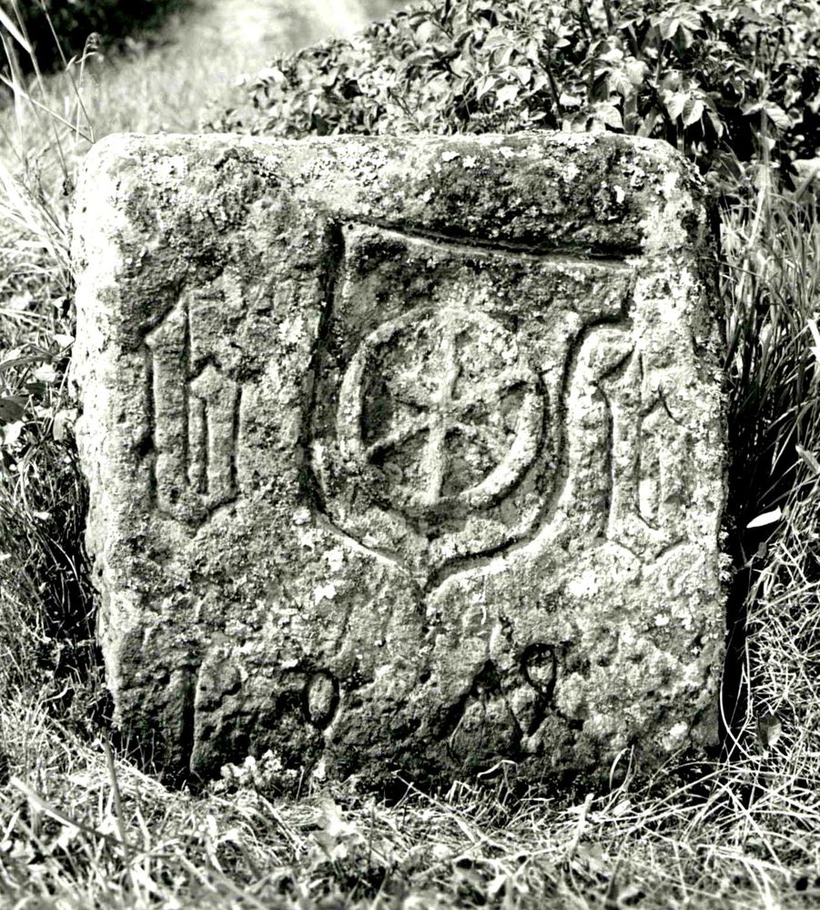 Schwarzweißfoto des Ecksteins von 1474 mit Wappenschild, Mainzer Rad, zwei großen b und der Jahreszahl.