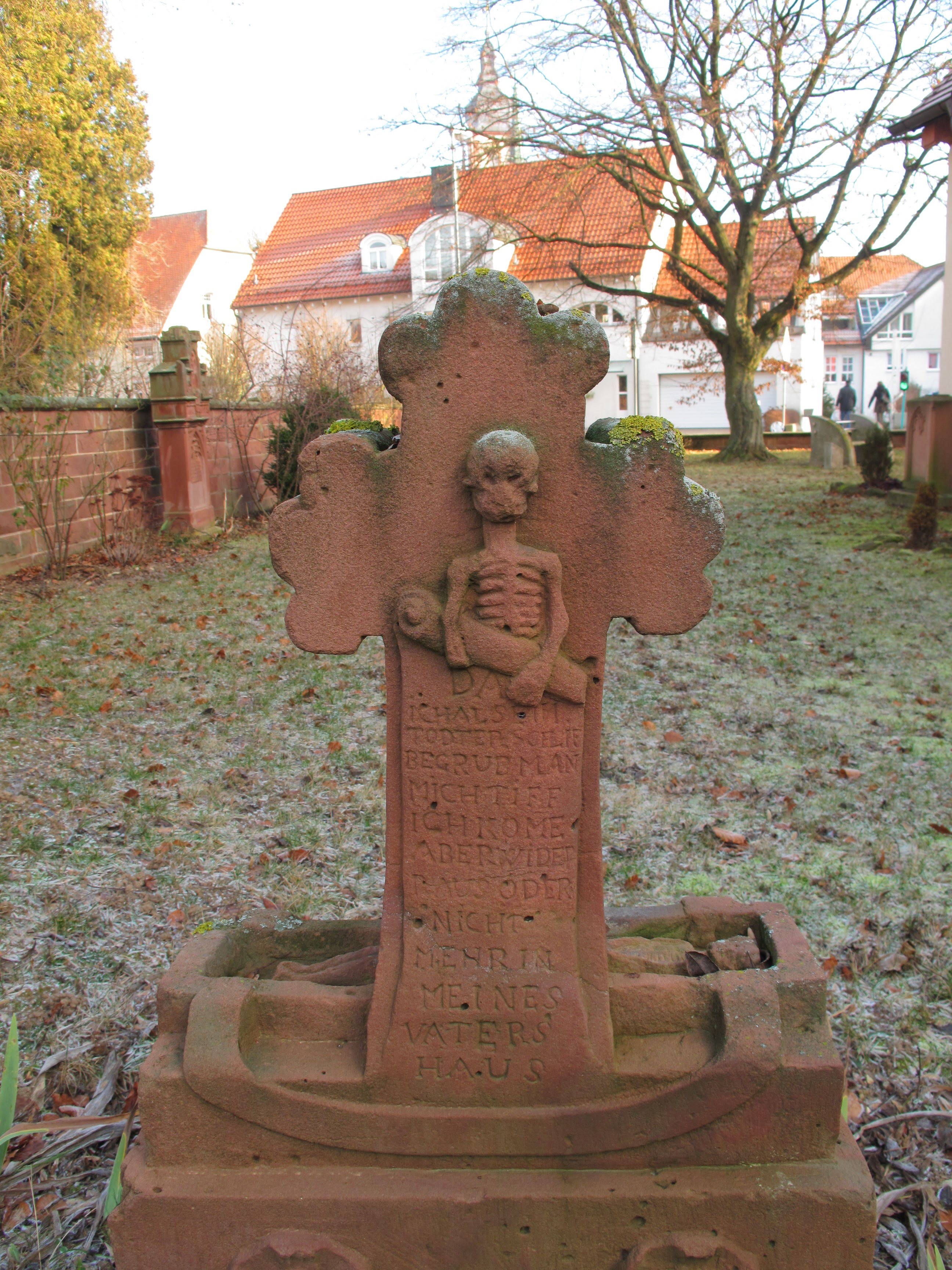 Freistehender Grabstein mit Kleeblattkreuz im Garten der Peterskapelle