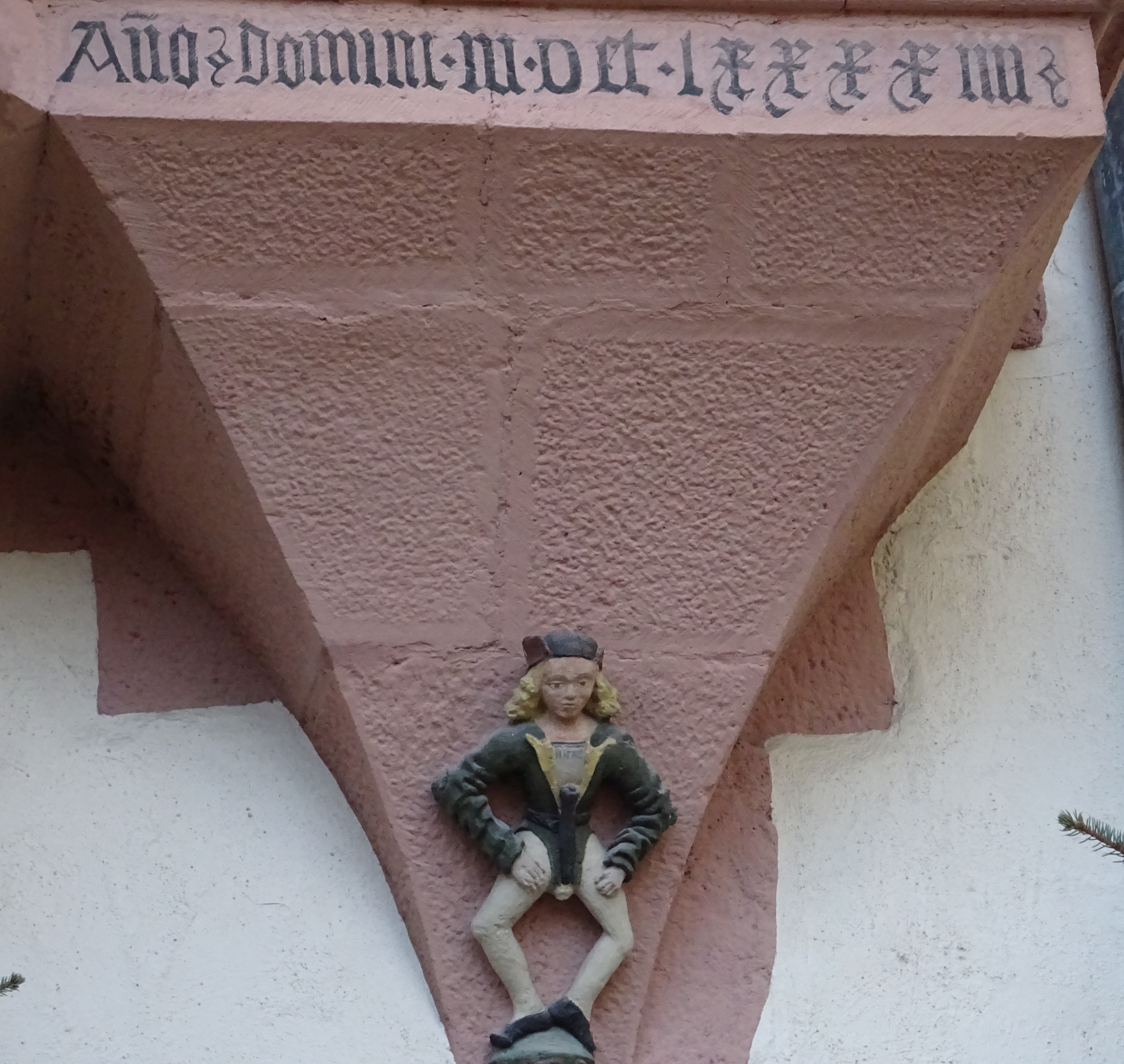 Jahresinschrift und Steinmetzfigur am Schloss