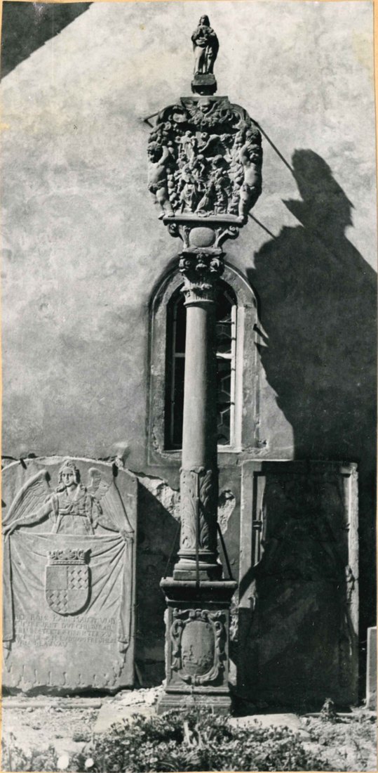 Kolb Nr. 127: Der Block-Bildstock vor der Außenwand der Peterskapelle, mit einer Grabplatte im Hintergrund. Foto: Dr. Josef Ihringer (1952 bis 1958), Archiv der Tauberfränkischen Heimatfreunde.