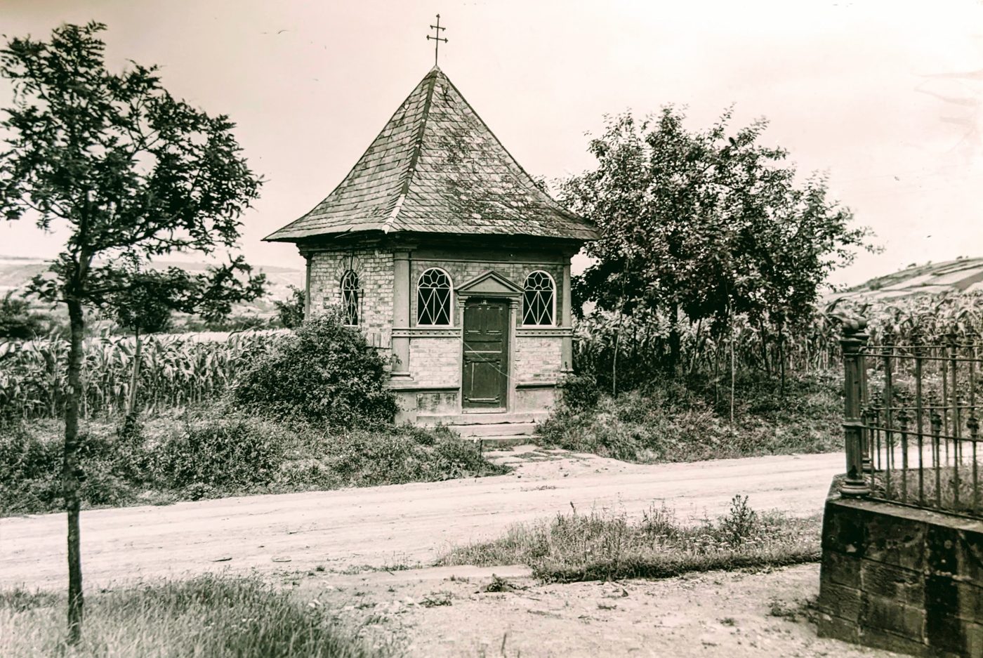 Die Kapelle am ursprünglichen Standort an der alten Würzburger Straße, nach dem Umbau von 1892; rechts die Einfriedung des Soldatengrabs. Archiv der Tauberfränkischen Heimatfreunde, Foto: Joseph oder August Heer.
