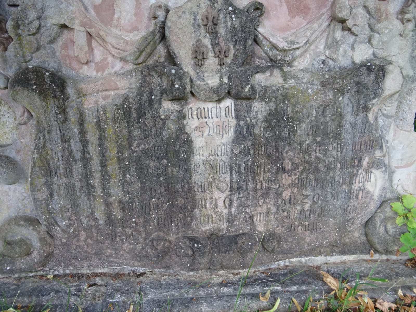 Inschrift und Wappen am Sockel, sehr schwer lesbar.